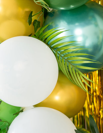 Gros plan sur les ballons et les feuilles de palmier du kit arche de 86 ballons tropicale