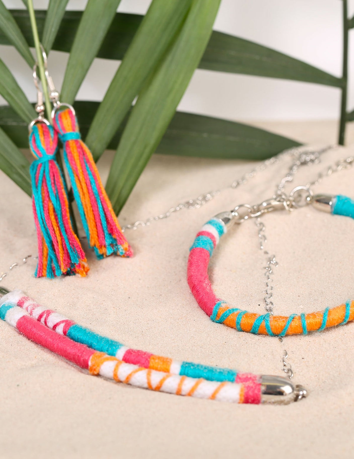 Détail des boucles d'oreilles à pompons et du bracelet du kit création de bijoux parure
