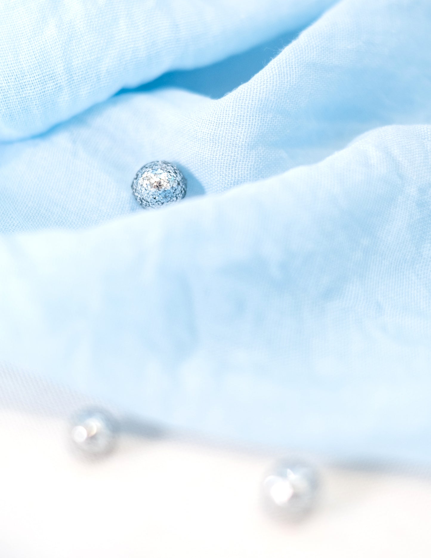 Détail de la texture des confettis de table mini boules pailletées argentées