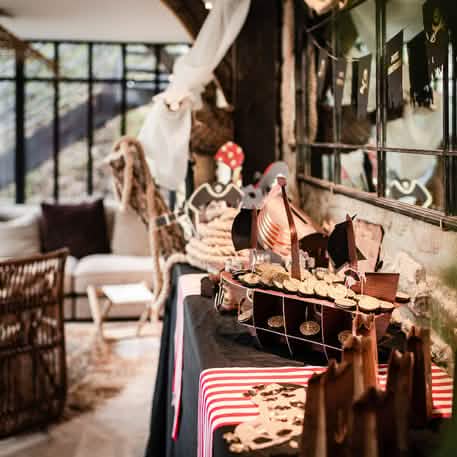 Mise en scène sur une table de fête du présentoir bateau pirate pour gâteaux