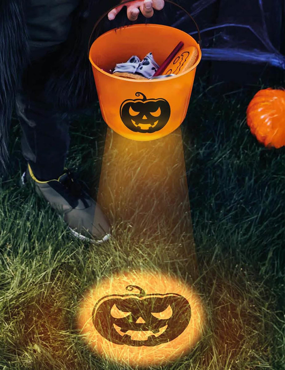 Seau à bonbon lumineux citrouille pour enfant orange avec projection lumineuse au sol